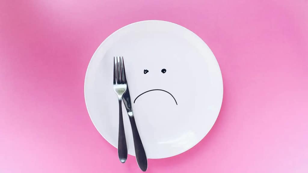 Intermittent fasting unhappy face on a plate